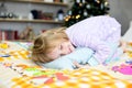 Christmas morning,a little girl in pajamas is lying in bed and hugging a pillow Royalty Free Stock Photo