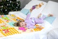 Christmas morning, a little girl in pajamas is lying in bed Royalty Free Stock Photo