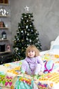 Christmas morning, a little girl in pajamas is lying in bed Royalty Free Stock Photo