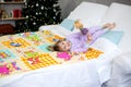 Christmas morning, a little girl in pajamas is lying in bed Royalty Free Stock Photo