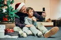 Christmas morning with my little dude. an adorable little boy taking selfies with his father while unwrapping Christmas Royalty Free Stock Photo