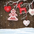 Christmas motive, various red and white decorations hanging on dry branch in front of brown wooden wall, illustration