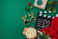 Christmas movie night and party concept with popcorn, Santa hat, decorations and movie clapper board on green background. Top Royalty Free Stock Photo