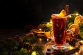 Christmas mulled red wine with spices and fruits in tall glass on wooden rustic table. Traditional Christmas or NewYear warming Royalty Free Stock Photo