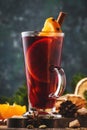 Christmas mulled red wine with spices and fruits in tall glass on wooden rustic table. Traditional Christmas or NewYear warming Royalty Free Stock Photo