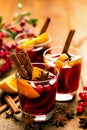 Christmas mulled red wine with spices and oranges on a wooden rustic table. Traditional hot drink at Christmas time