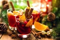 Christmas mulled red wine with spices and oranges on a wooden rustic table. Traditional hot drink at Christmas time