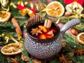 Christmas mulled wine with cinnamon, orange and star anise in a ceramic bowl with winter decorations