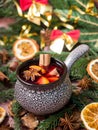 Christmas mulled wine with cinnamon, orange and star anise in a ceramic bowl with winter decorations