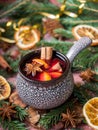 Christmas mulled wine with cinnamon, orange and star anise in a ceramic bowl with winter decorations