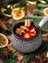 Christmas mulled wine with cinnamon, orange and star anise in a ceramic bowl with winter decorations