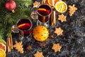 Christmas mulled wine with ginger biscuits orange cinnamon clove anise and fir tree on the dark table Royalty Free Stock Photo