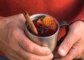 Christmas mulled wine in Hand of old man, delicious holiday like parties with orange cinnamon star anise spices. Traditional hot Royalty Free Stock Photo