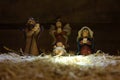 Christmas nativity scene of baby Jesus in the manger over straw. Infant Jesus, Angel, virgin Mary and Joseph colored figurines Royalty Free Stock Photo