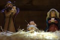 Christmas nativity scene of baby Jesus in the manger over straw. Infant Jesus, virgin Mary and Joseph colored figurines Royalty Free Stock Photo