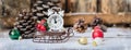 Christmas and New year alarm clock with snow on wooden sled with cones and toys, banner Royalty Free Stock Photo