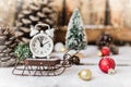 Christmas and New year alarm clock with snow on wooden sled with cones and toys, snowflakes texture Royalty Free Stock Photo