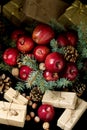 Christmas and New year. Apples with pine cones and nuts in a basket with fir branches. Gifts and candles. Royalty Free Stock Photo