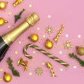 Christmas and New Year background. Champagne bottle, golden christmas balls, festive ribbons, fir branches, star confetti on pink Royalty Free Stock Photo