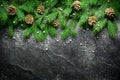 Christmas and New Year background. Christmas tree branch on a black background. Cones and fur-tree toys. View from above. Royalty Free Stock Photo