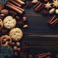 Christmas or New Year background with cookies, spices, cinnamon, nuts and fir tree branch on dark wooden background Royalty Free Stock Photo