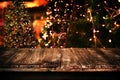 Christmas and New year background with empty dark wooden deck table over christmas tree and blurred light bokeh Royalty Free Stock Photo