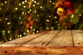 Christmas and New year background with empty dark wooden deck table over christmas tree and blurred light bokeh. Royalty Free Stock Photo