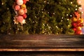 Christmas and New year background with empty dark wooden deck table over christmas tree and blurred light bokeh Royalty Free Stock Photo