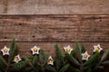 Christmas or New Year background with fir branches, garland, Christmas balls, gift box, wooden snowflakes and stars on dark wooden Royalty Free Stock Photo