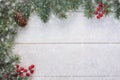 Christmas New Year background with fir tree, pinecone, red berries and snow on a white wooden background. Copy space for your text Royalty Free Stock Photo