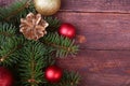 Christmas or New Year background: fur-tree, branches, colored glass balls , decoration and cones on a wooden background Royalty Free Stock Photo