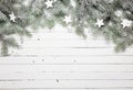 Christmas or New Year background: fur-tree branches, decoration and glittering stars on wooden background, top view Royalty Free Stock Photo