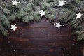 Christmas or New Year background: fur-tree branches, decoration and glittering stars on wooden background, top view Royalty Free Stock Photo