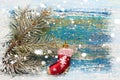 Christmas new year background. Red toy sock Santa Claus on wooden background and snow-covered spruce branches. Toned. Copy space Royalty Free Stock Photo