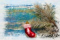 Christmas new year background. Red toy sock Santa Claus on wooden background and snow-covered spruce branches. Toned. Copy space Royalty Free Stock Photo
