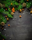 Christmas and New Year background. Christmas tree branch on a black background. Cones and fur-tree toys. View from above. Royalty Free Stock Photo