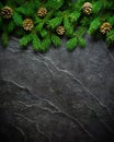 Christmas and New Year background. Christmas tree branch on a black background. Cones and fur-tree toys. View from above. Royalty Free Stock Photo