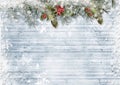 Christmas and New Year beautiful background with snow-covered branches, holly and snowflakes on snowy wooden boards. Christmas