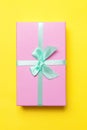 Christmas New Year birthday valentine celebration present romantic concept. Pink gift box isolated on yellow background