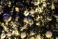 Christmas or New Year blurred bokeh background, christmas decorations silver and white balls on green pine branches close up Royalty Free Stock Photo