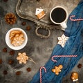 Christmas or New year breakfast. Frame of gingerbread, candy cane and coffee cup on dark table. Flat lay. Top view