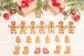 Christmas and New Year card with a composition of gifts, Christmas tree decorations and gingerbread men on a white wooden Royalty Free Stock Photo