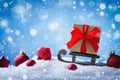 Christmas or New Year card. Golden gift or present box on sledge in snowy background