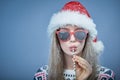 Frozen girl with snow on face wearing Santa hat and sunglasses