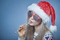 Frozen girl with snow on face wearing Santa hat and sunglasses