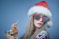 Frozen girl with snow on face wearing Santa hat and sunglasses