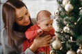 Christmas or New year celebration. Happy mother with her daughter sit near a christmas tree