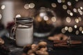 Christmas and new year decoration background with round bokeh garland, cinnamon, cookies, cones, nuts and candle in cup