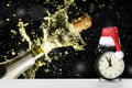 Christmas or New Year celebration theme with explosion of splashing champagne sparkling wine near vintage alarm clock with Santa Royalty Free Stock Photo