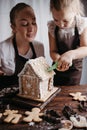 Mother and daughter decorating gingerbread house Royalty Free Stock Photo